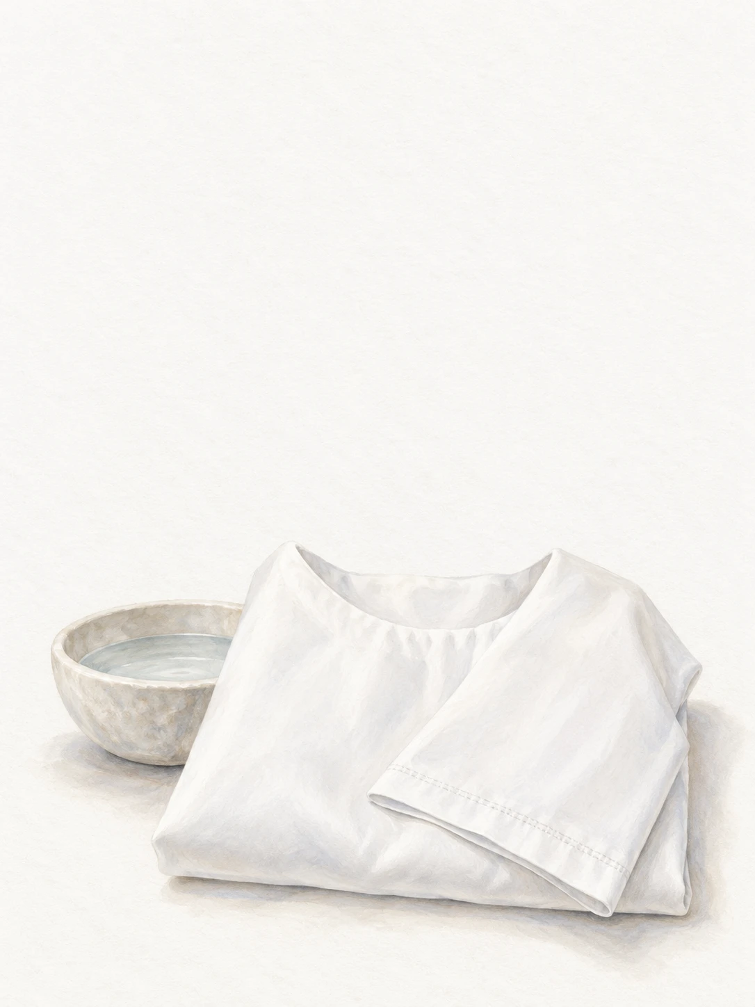A folded white baptismal garment beside a small bowl of water.