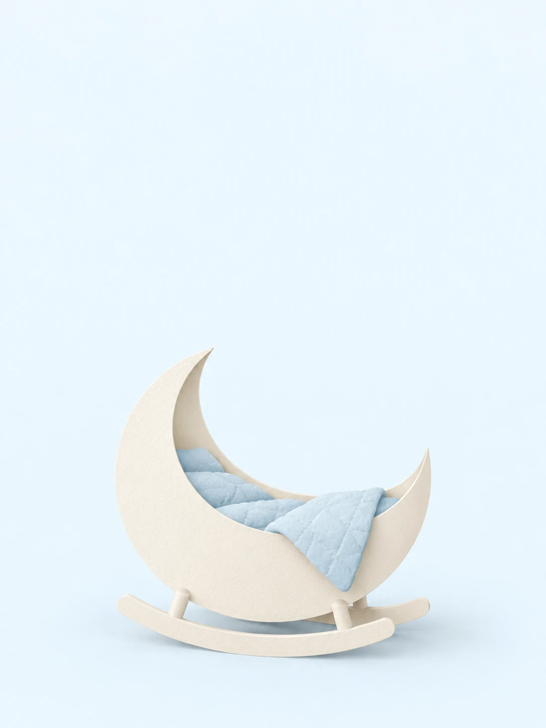 A sculpted cream crescent cradle with a soft blue quilt rests on two small rockers.