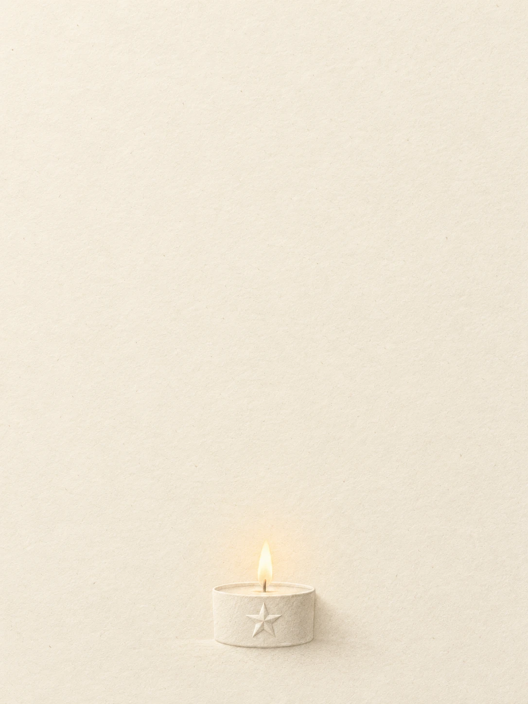 A small ivory candle cup with a subtle raised star and a quiet flame.