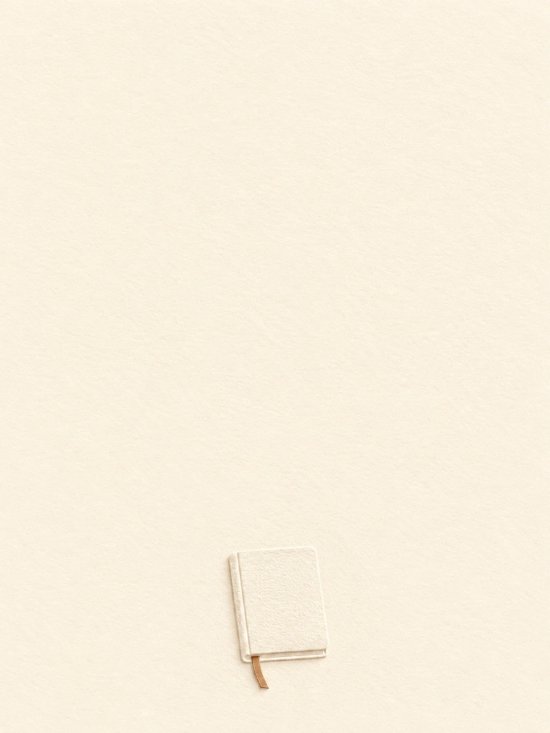 A little closed ivory notebook and pale ribbon bookmark are pressed into cotton paper.