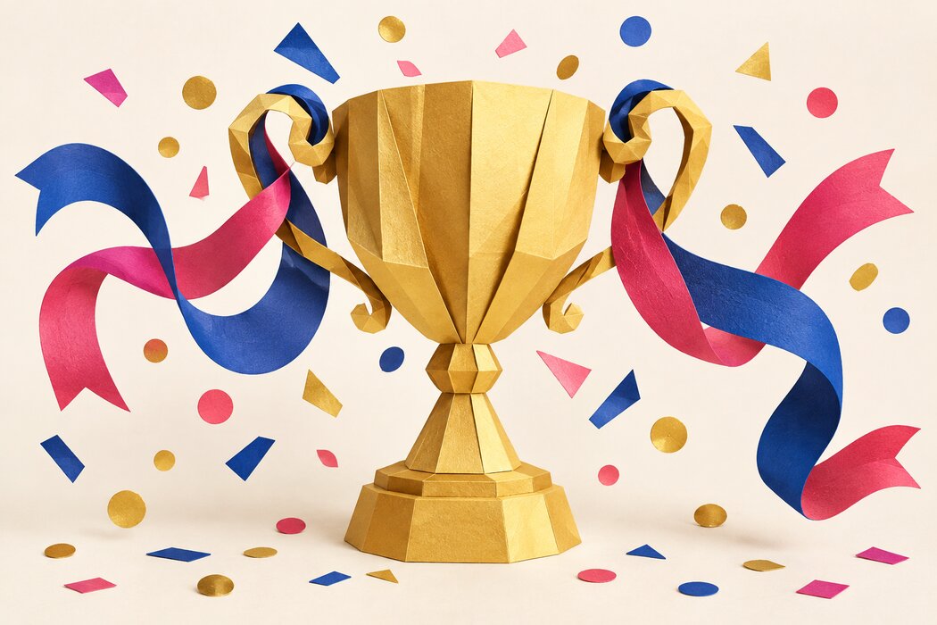 A sculptural gold paper trophy with colorful ribbons.