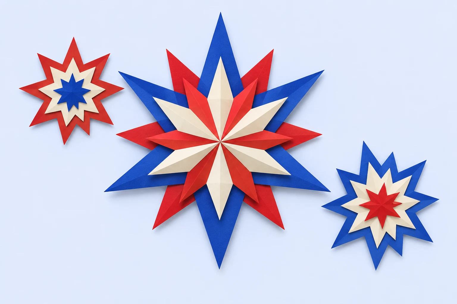 Three red, ivory and blue cut-paper starbursts.